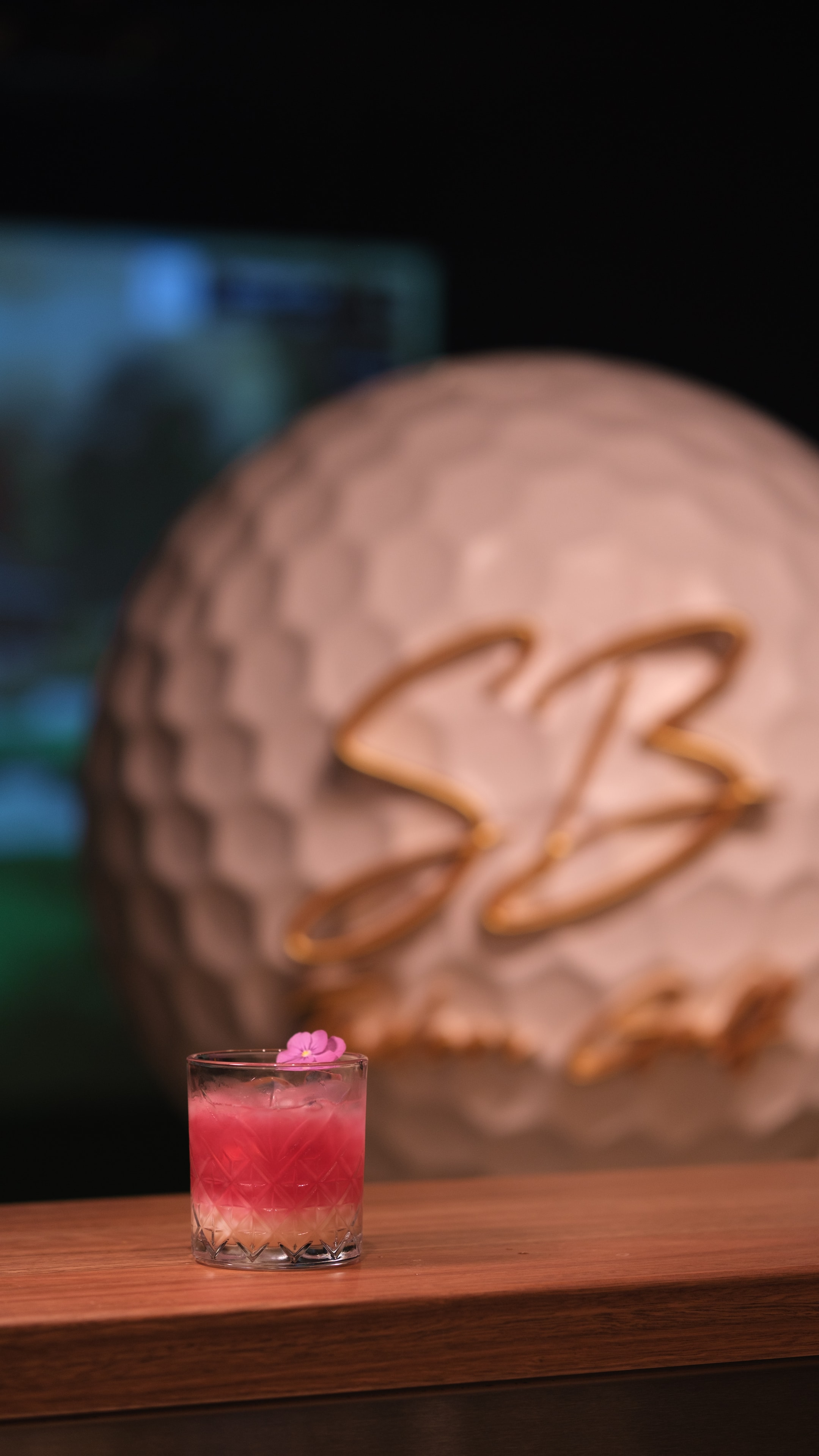 Signature cocktail — pink with flower garnish