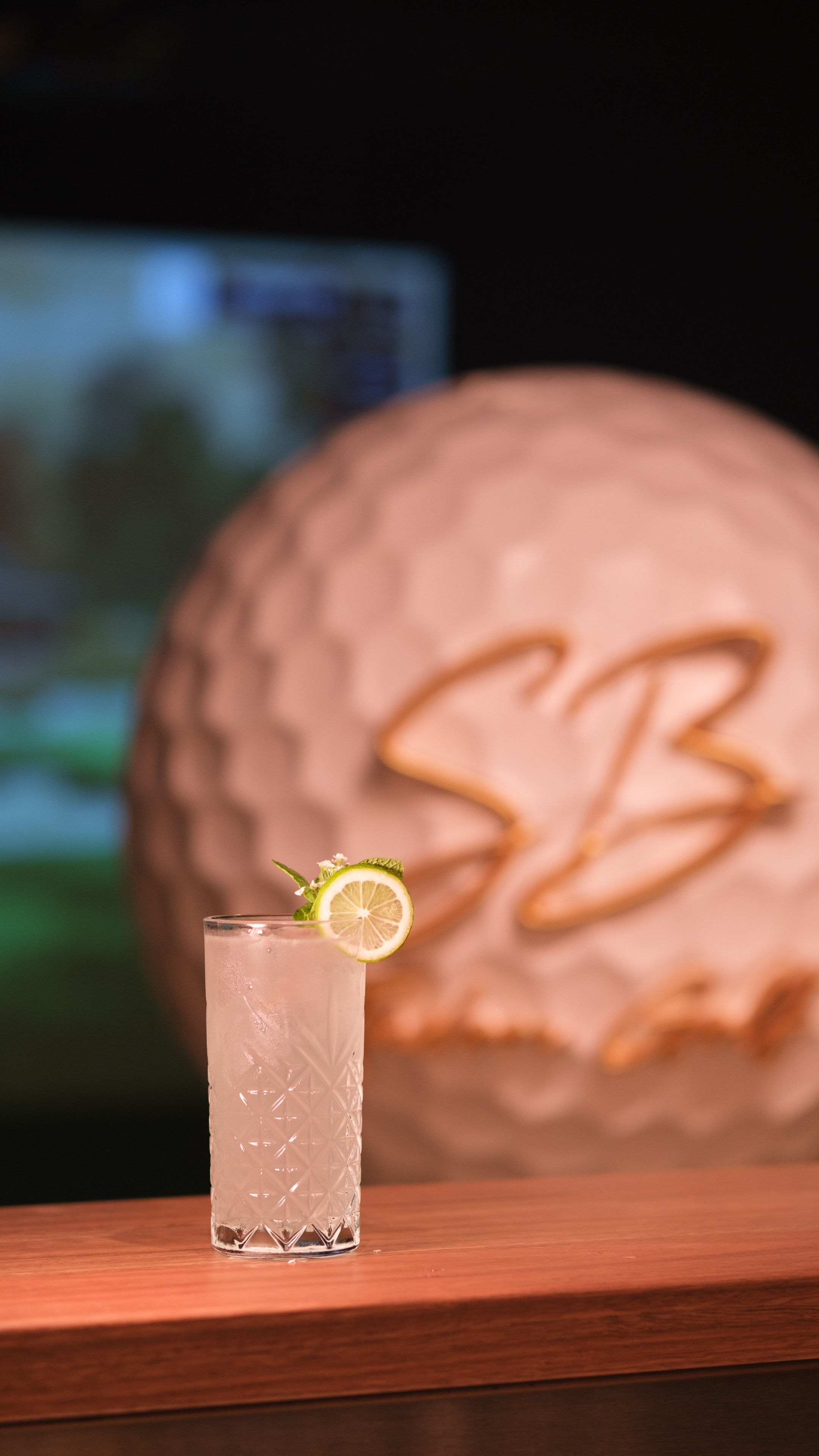 Signature cocktail — pink with lime garnish